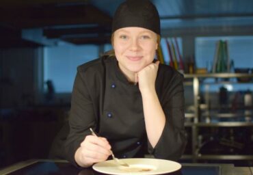 Kokkiopiskelija hymyilee.