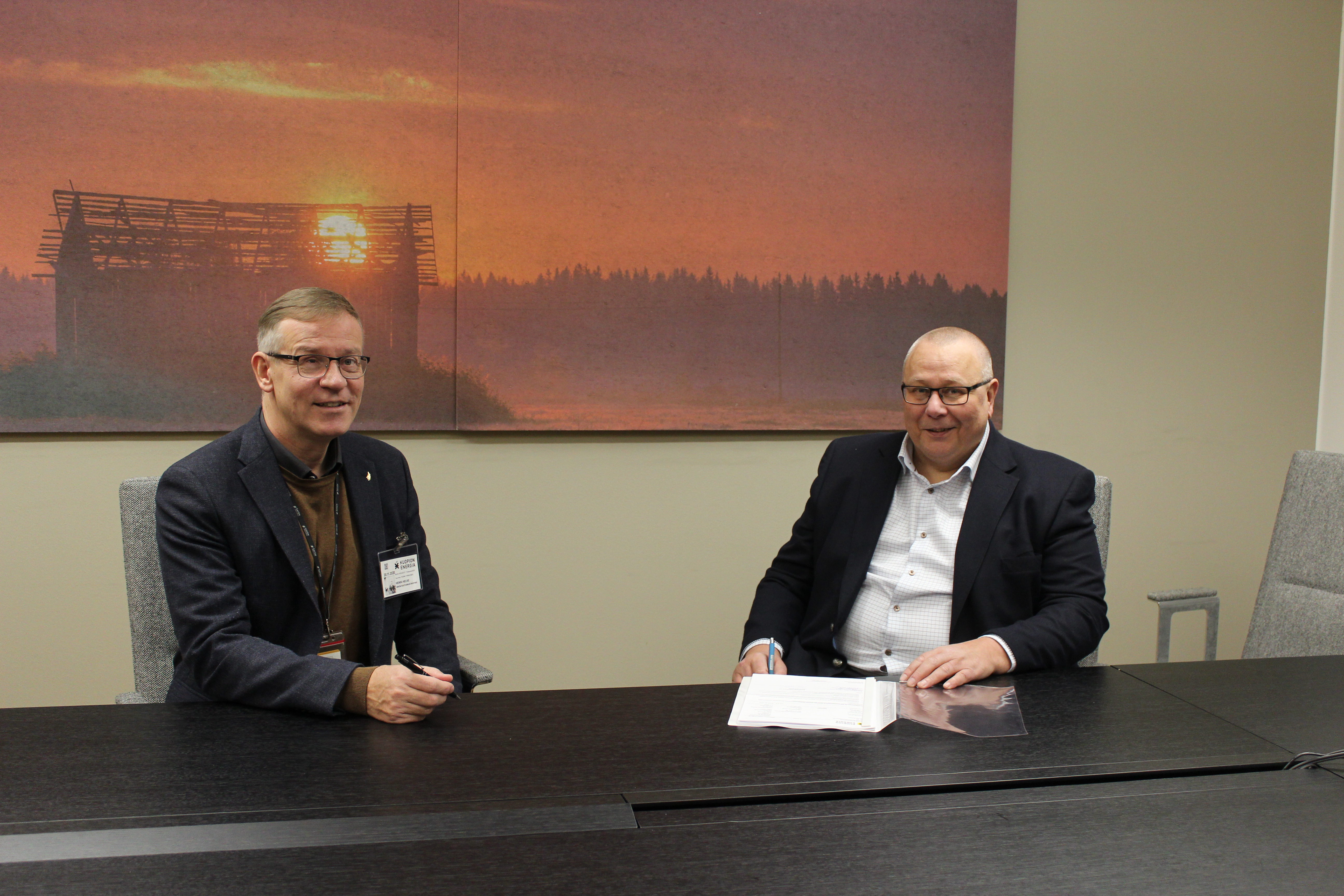Savon koulutuskuntayhtymän johtaja Heikki Helve ja Kuopion energian toimistusjohtaja Esa Lindholm istuvat pöydän ääressä.