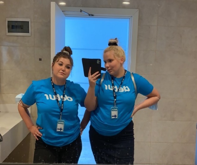 Kaksi naista matkanjärjestäjän sinisissä paidoissa.