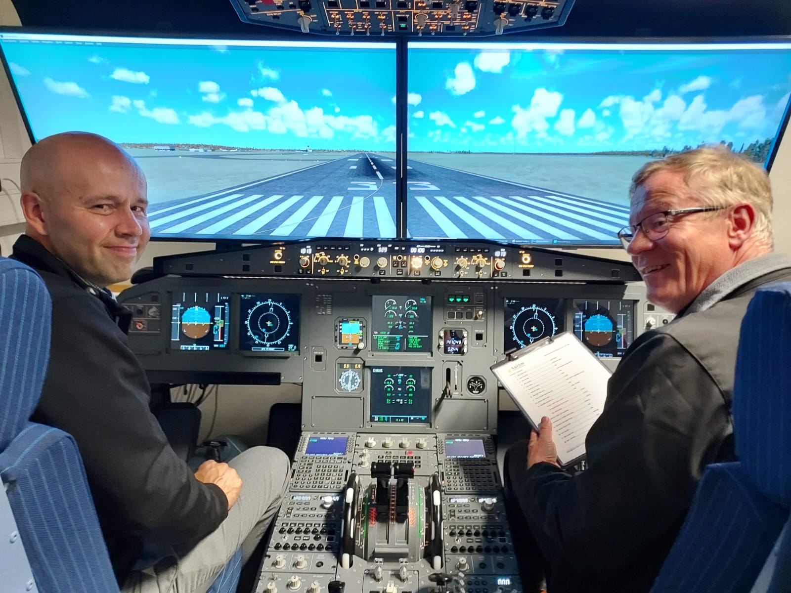 Kunnanjohtaja Janne Airaksinen ja Savon koulutuskuntayhtymän johtaja Heikki Helve lentokonesimulaattorissa.
