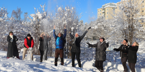 Kipsimestari opiskelijat ja opettajat heittävät lunta ilmaan.