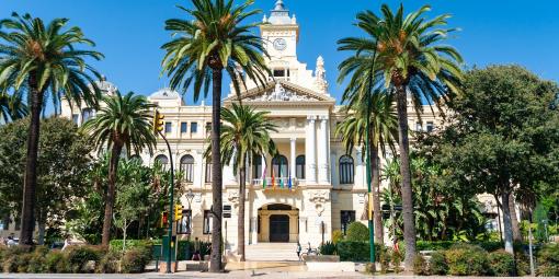 Palmujen ympäröimä valkoinen hallintorakennus Malagassa Espanjassa.