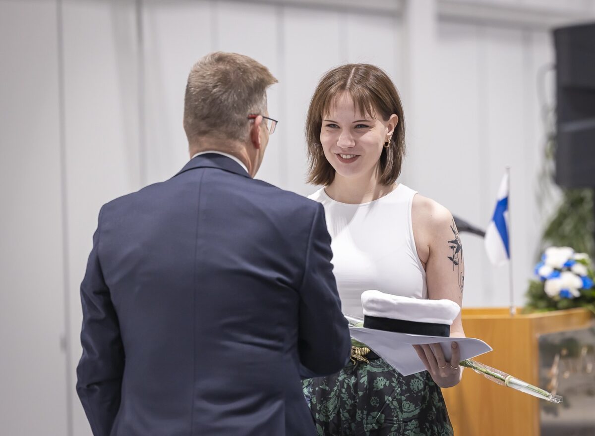 Opettaja onnittelee valkolakin saanutta.
