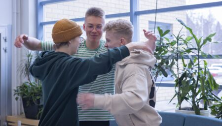 Kolme opiskelijaa ryhmähalauksessa.