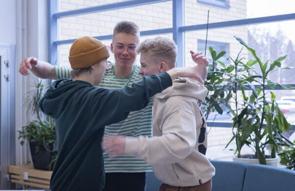 Kolme opiskelijaa ryhmähalauksessa.