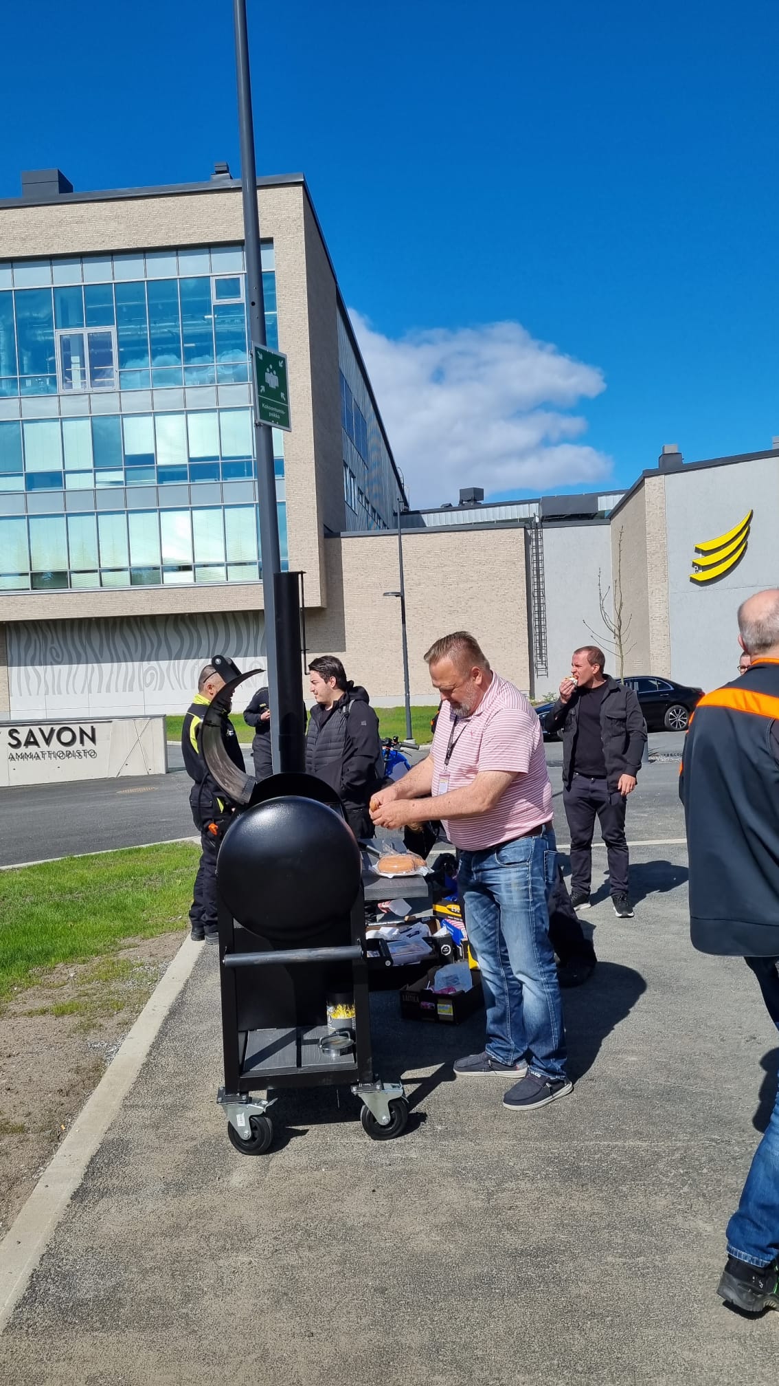 Opiskelijat grillaamassa makkaraa ulkona.