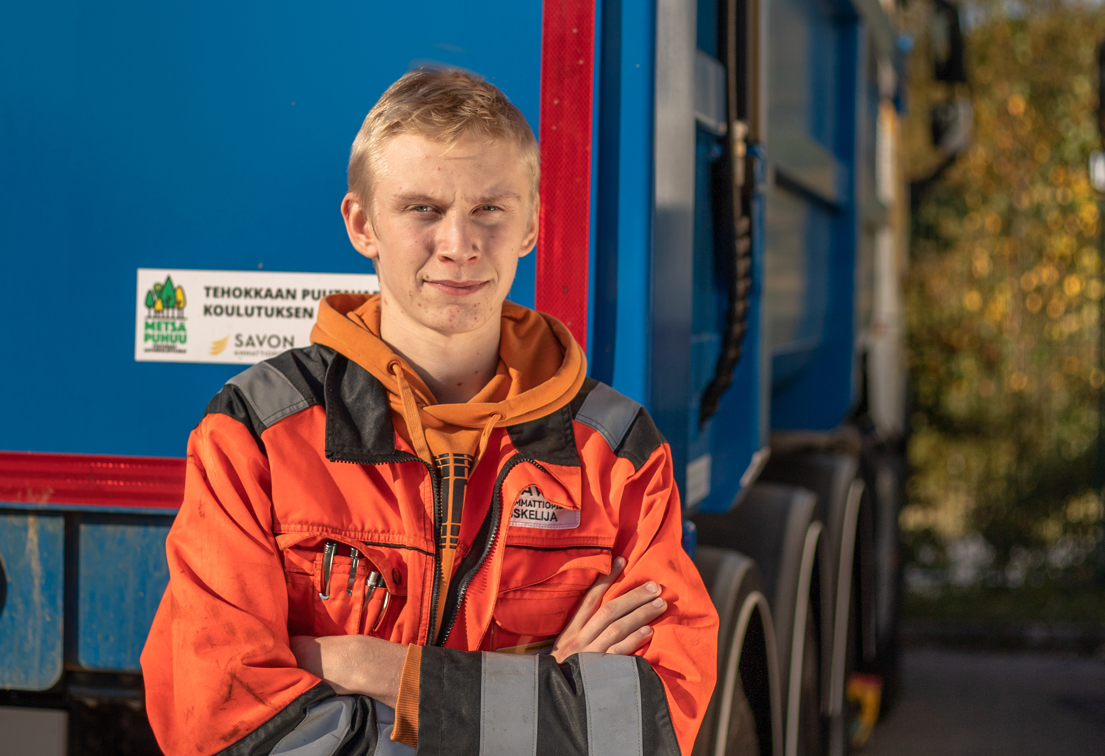 Logistiikan mies seisoo auton edessä.