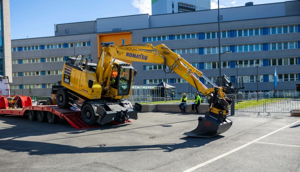 Kuormalavalta lasketaan kaivinkone alas.