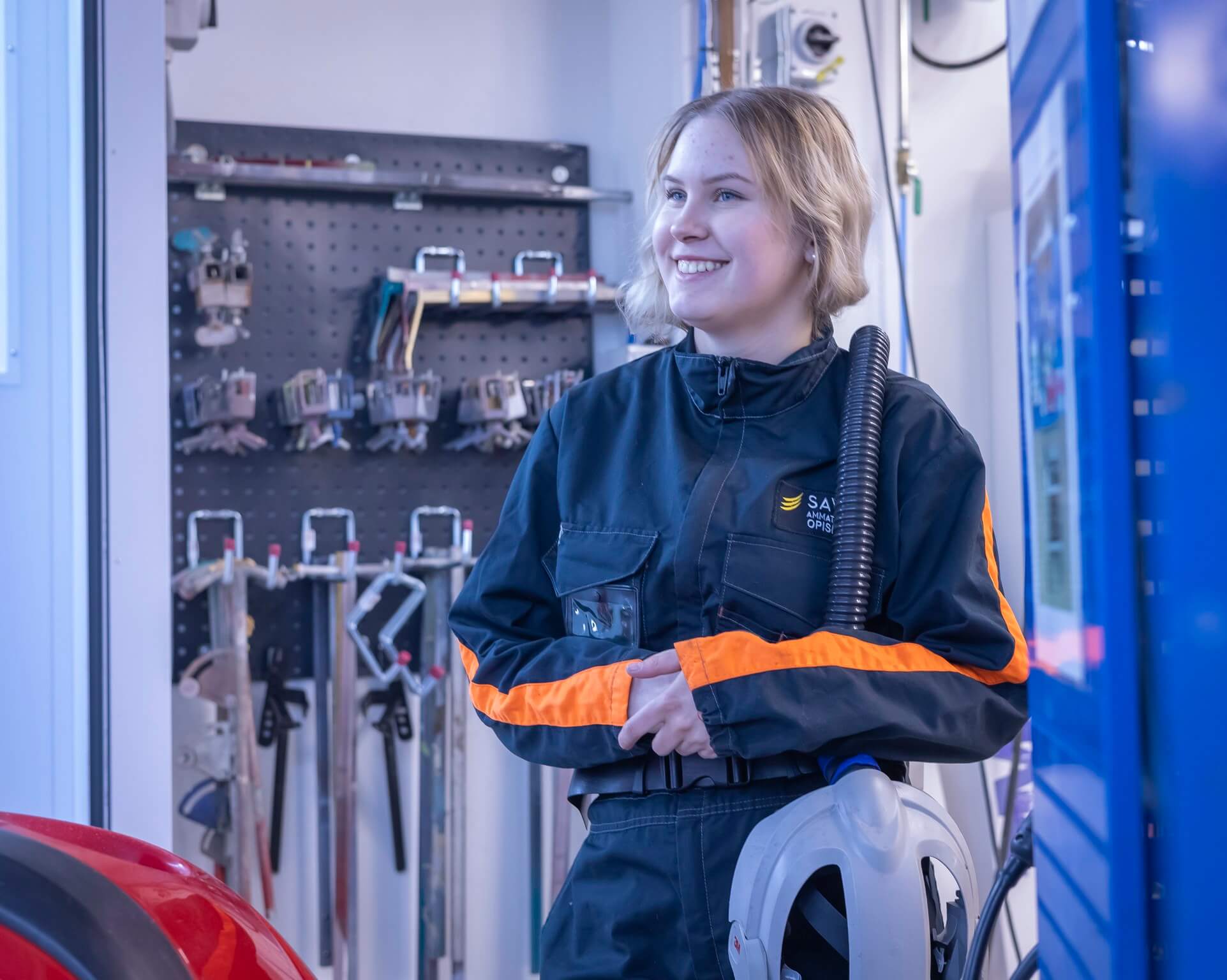 opiskelija hymyilee suojavarusteet yllään.