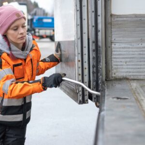 Opiskelija sulkee kuorma-auton sivuovea.
