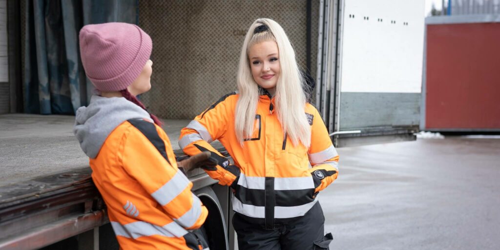kaksi opiskelijaa nojaa rekkaan.