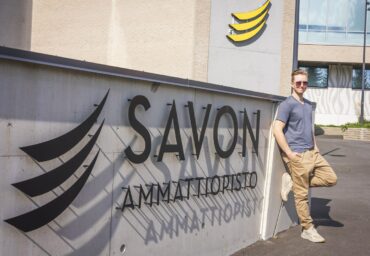 Savon ammattiopisto lukee kohokirjaimin seinässä ja mies nojaa seinään.