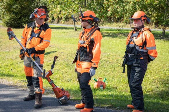 Raivaussahalla siistitään tien ympäristöä. Henkilöt miettivät kulkusuuntaa.