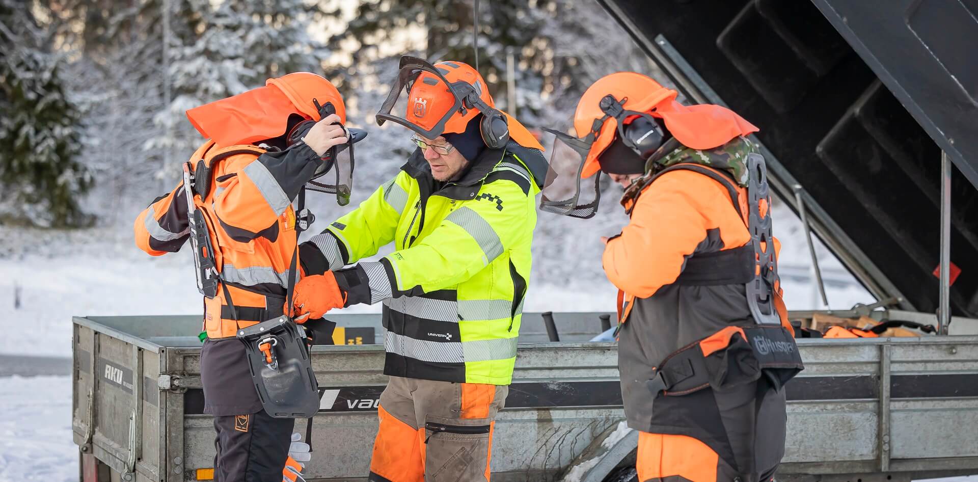 Opiskelijat laittavat raivaussahausta varten työasut ylle.