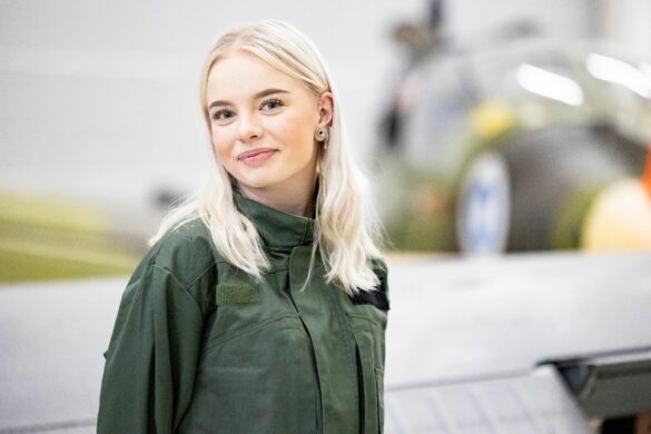 Opiskelijalla on iloinen ilme ja hän katsoo kameraan.