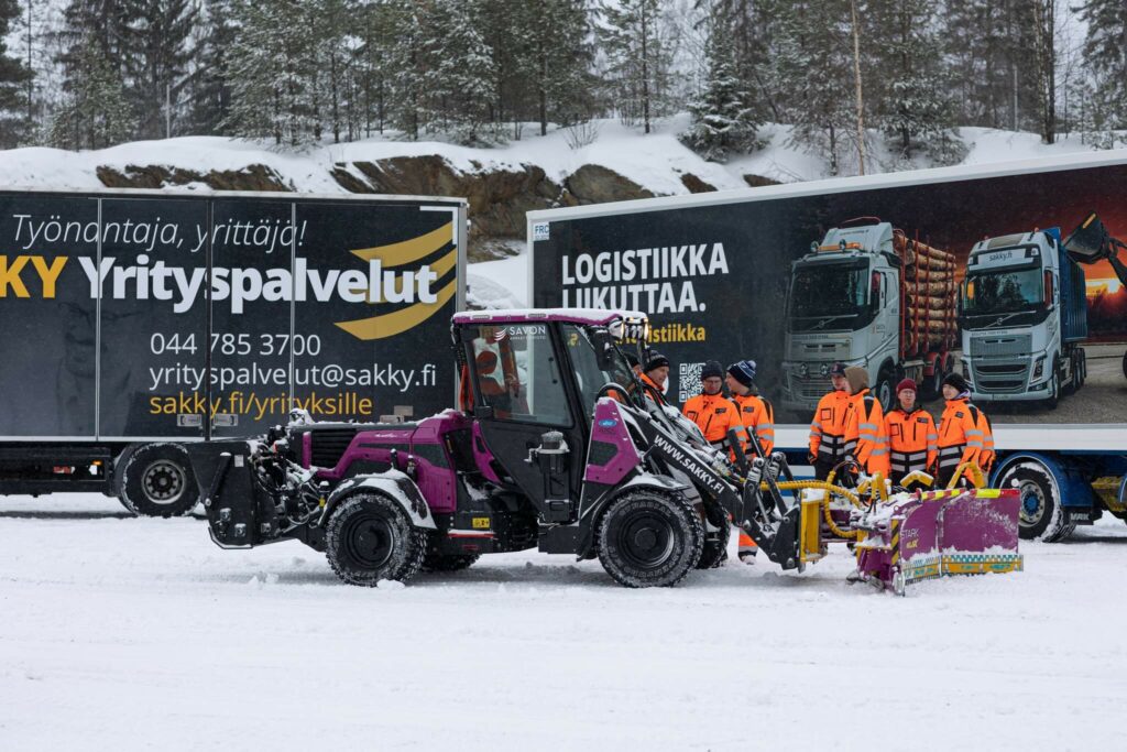 Taustalla rekka ja edessä kiinteistönhoitoon liittyvä puhdistuskone.