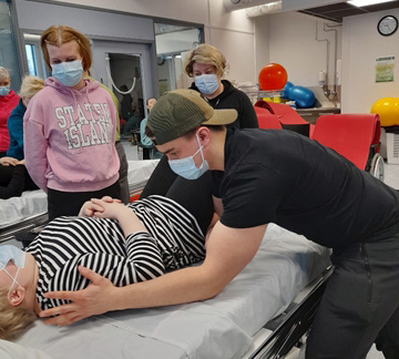 Kinestetiikan ammattilainen hoitaa asiakasta.
