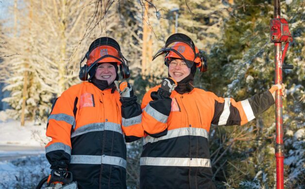 Kaksi iloista opiskelijaa yllään huomioasusteet ja kypärät.