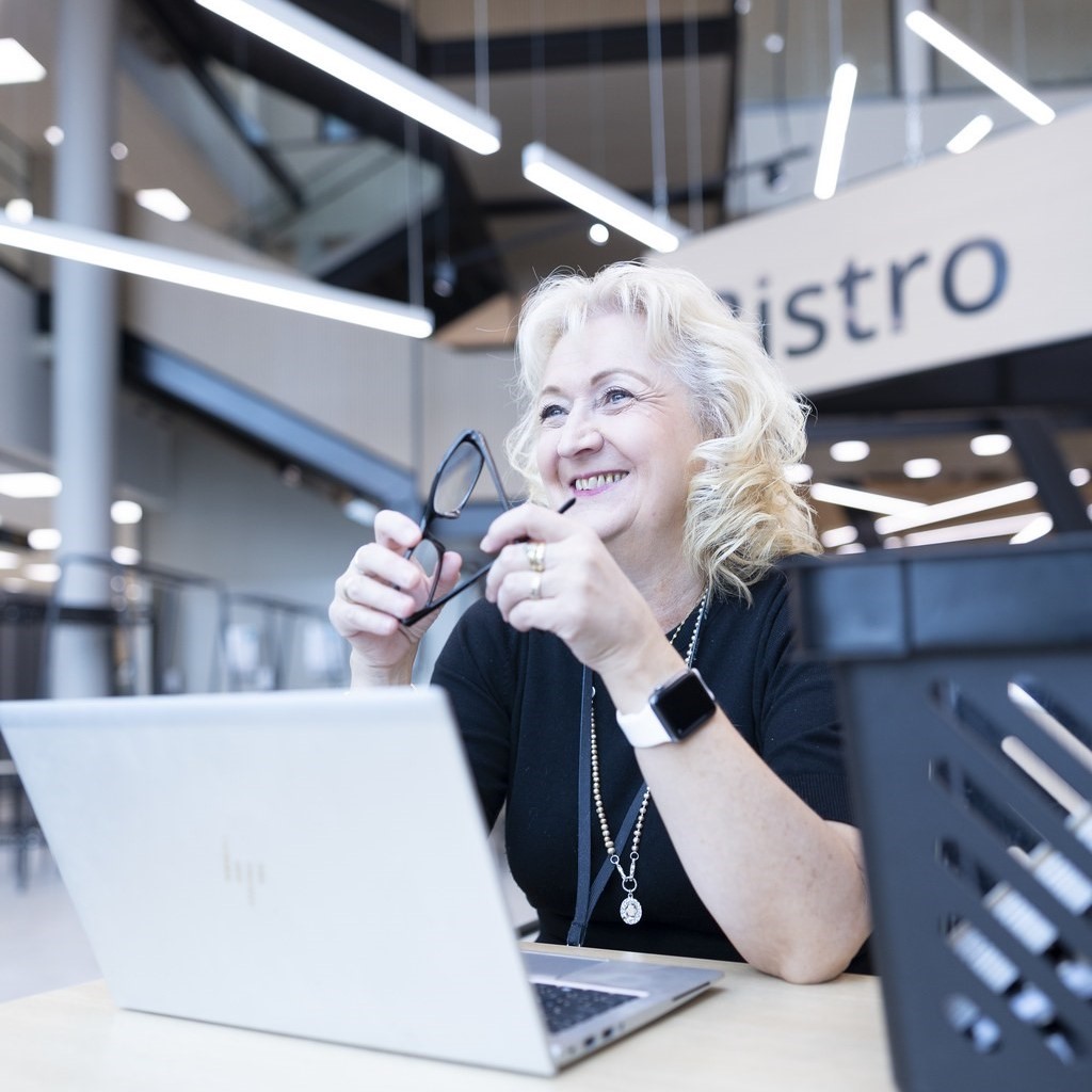 Nainen istuu tietokoneen ääressä.