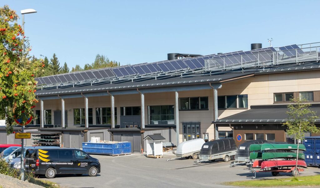 Toivalan kampuksen hallirakennus, pihalla autoja ja peräkärrejä