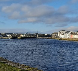 Maisemakuva Galwaysta Irlannista jossa edessä on meri ja taustalla taloja.