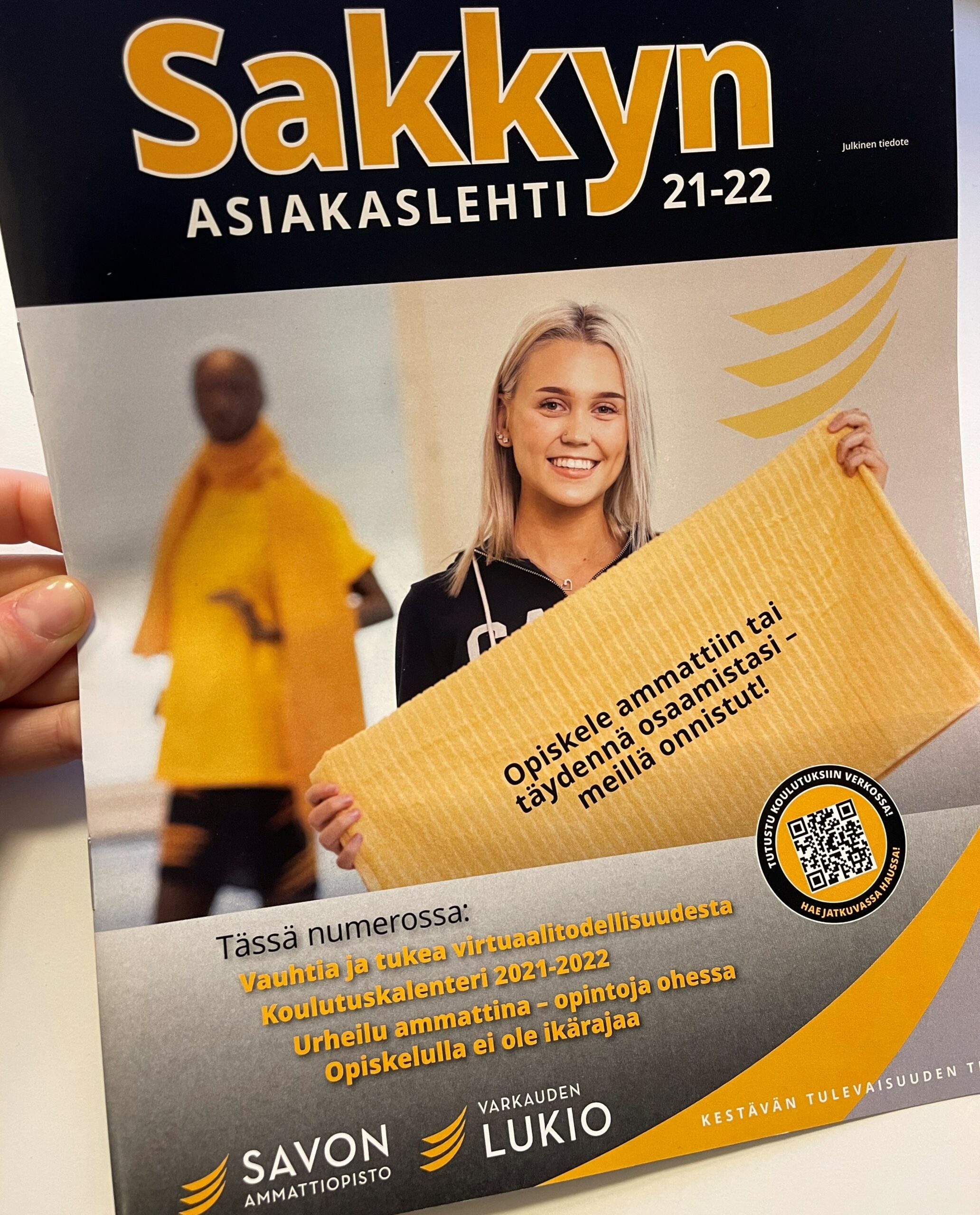 Asiakaslehti kädessä.