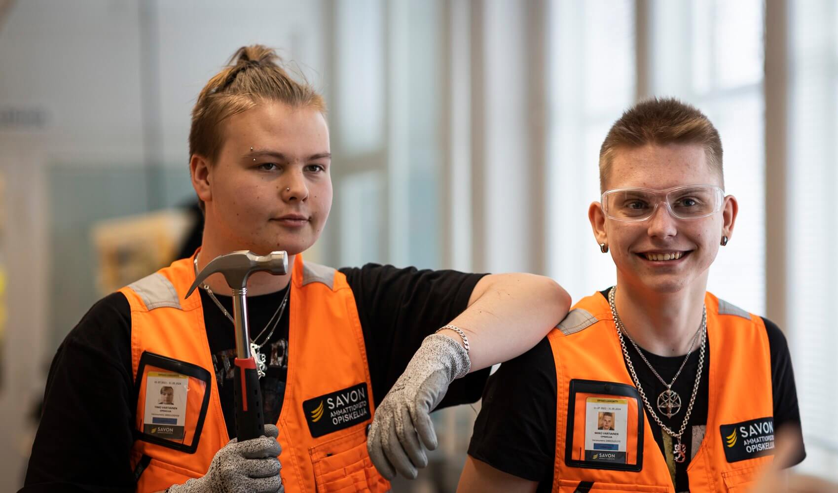 kaksi opiskelijaa joista toisella on kädessä vasara.