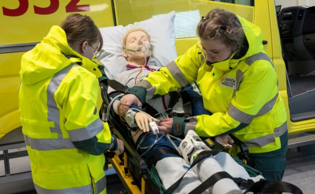 Hoitajat valmistelevat asiakasta ambulanssikyytiin.