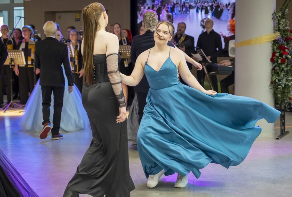Ihmisiä tanssii juhlapuvuissaan.