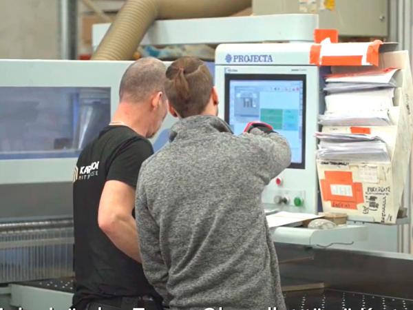 Kaksi miestä cnc-sorvin edessä.