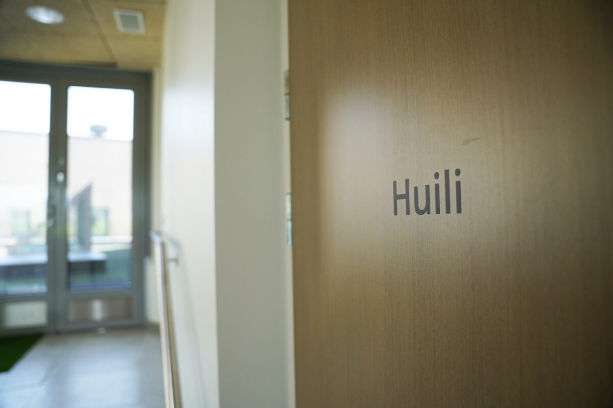 Puinen ovi, jossa lukee Huili.