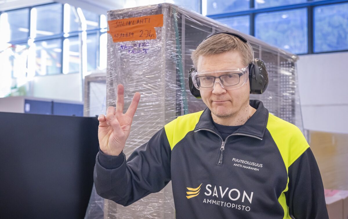 Ihminen näyttää voitonmerkkiä.