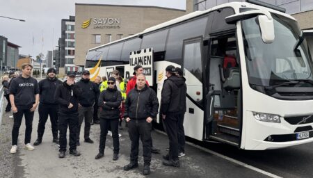 Ihmisiä seisoo linja-auton sivulla.