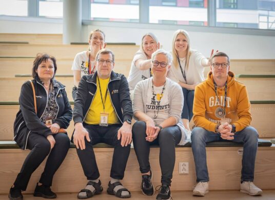 Opinto-ohjajaat istuvat iloisina portailla.